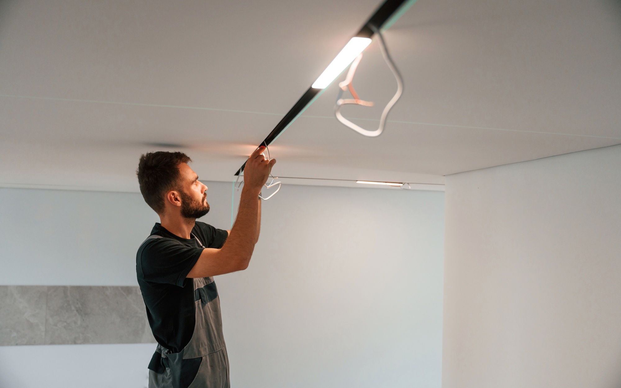 Man is working with lighting equipment indoors at domestic room